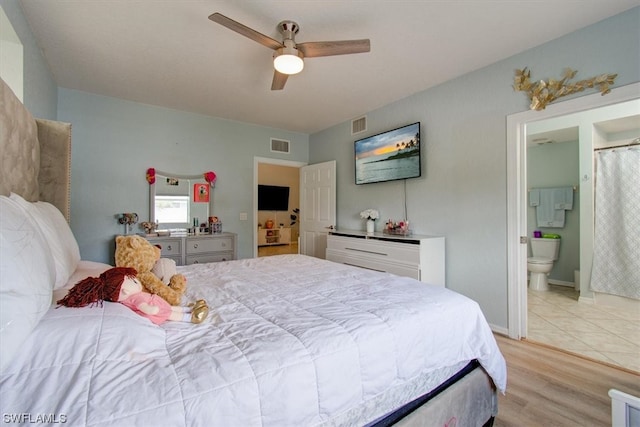 tiled bedroom featuring connected bathroom and ceiling fan