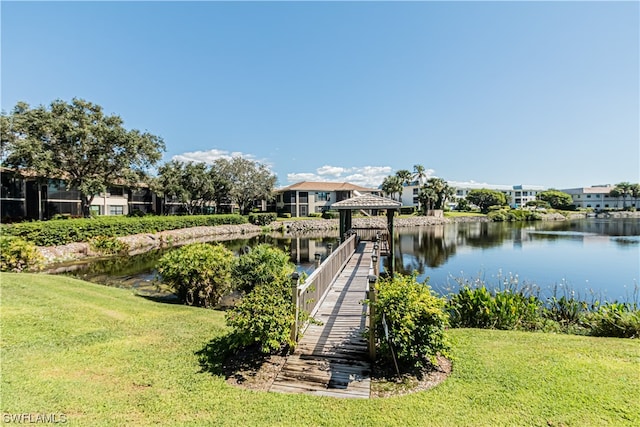 view of dock with a yard, a gazebo, and a water view