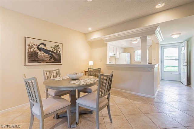 dining room with a textured ceiling, light tile flooring, and ceiling fan