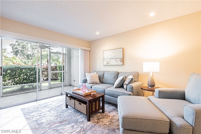 living room with a textured ceiling, ceiling fan, and light tile flooring