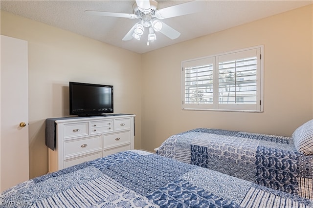 bedroom with a textured ceiling and ceiling fan