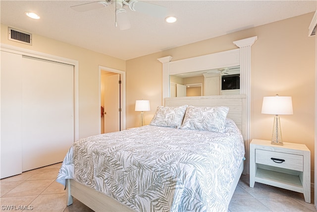 bedroom with light tile floors, a closet, and ceiling fan