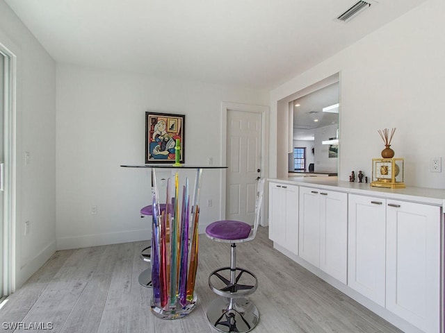 interior space with white cabinets and light hardwood / wood-style flooring