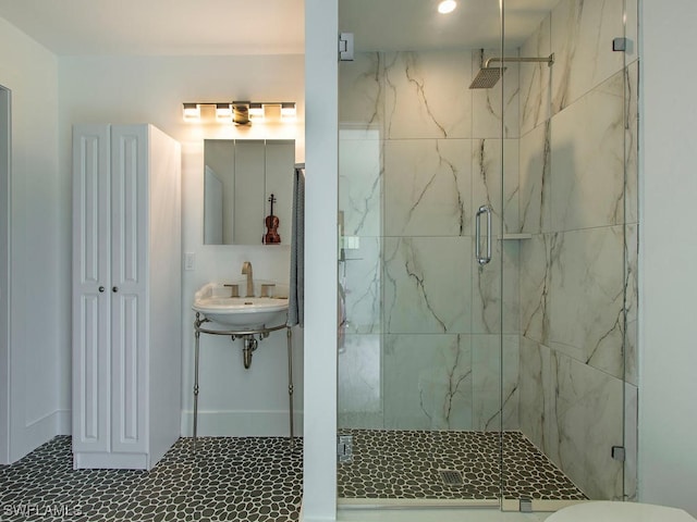 bathroom with a shower with door and sink