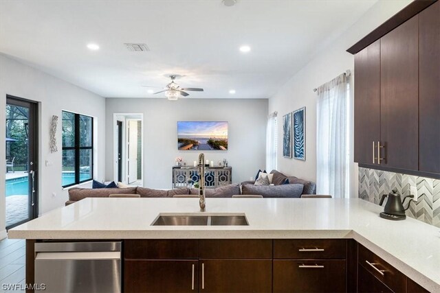 kitchen featuring tasteful backsplash, sink, ceiling fan, stainless steel dishwasher, and dark brown cabinetry