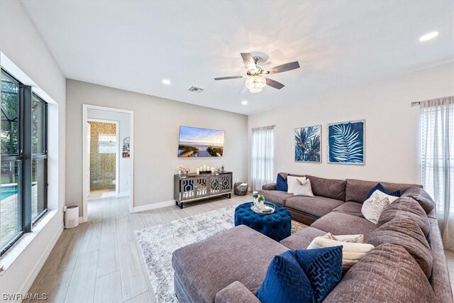 living room with ceiling fan and light hardwood / wood-style floors