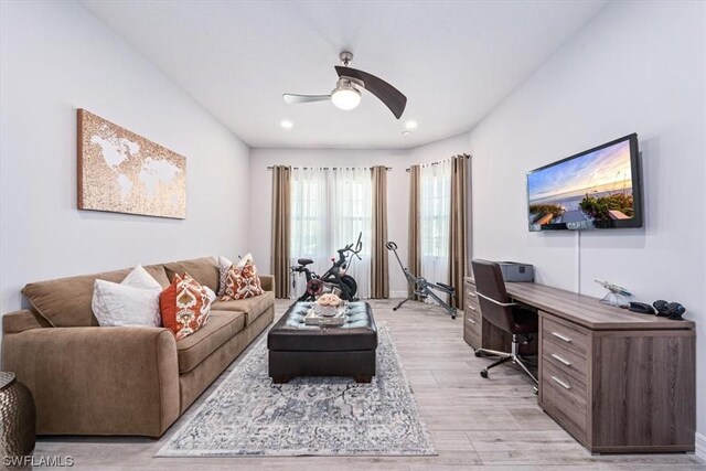 living room with light wood-type flooring and ceiling fan