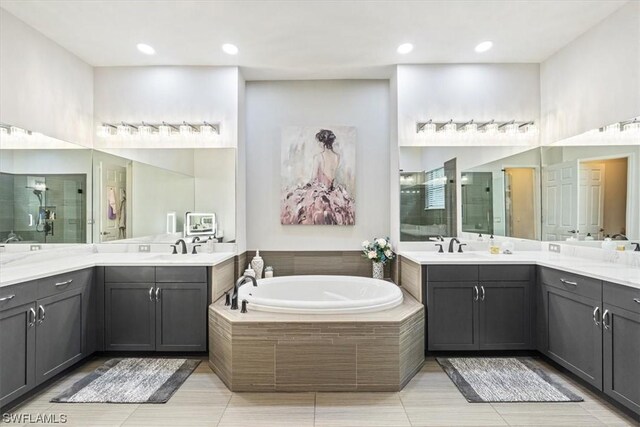 bathroom with tile patterned flooring, vanity, and shower with separate bathtub