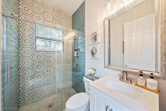 bathroom featuring an enclosed shower, toilet, and vanity