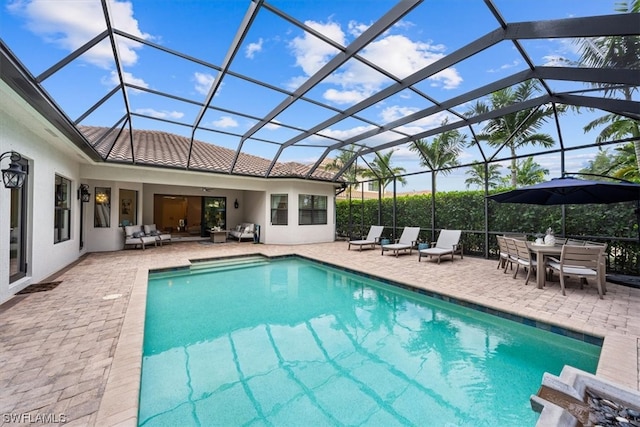 view of swimming pool featuring glass enclosure and a patio