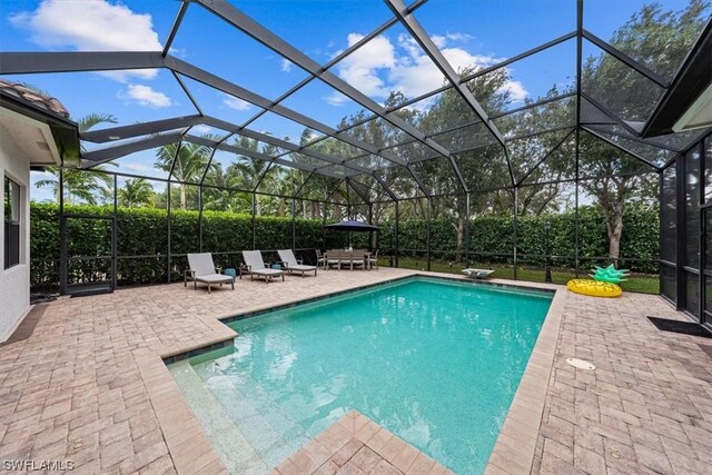 view of swimming pool with glass enclosure and a patio area