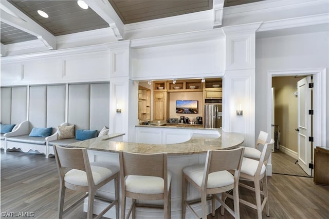 kitchen with crown molding, stainless steel fridge, beamed ceiling, and wood-type flooring