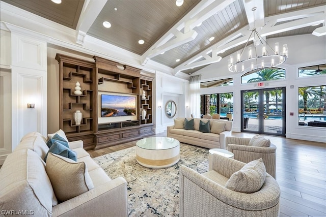 living room with high vaulted ceiling, an inviting chandelier, beamed ceiling, and wood-type flooring