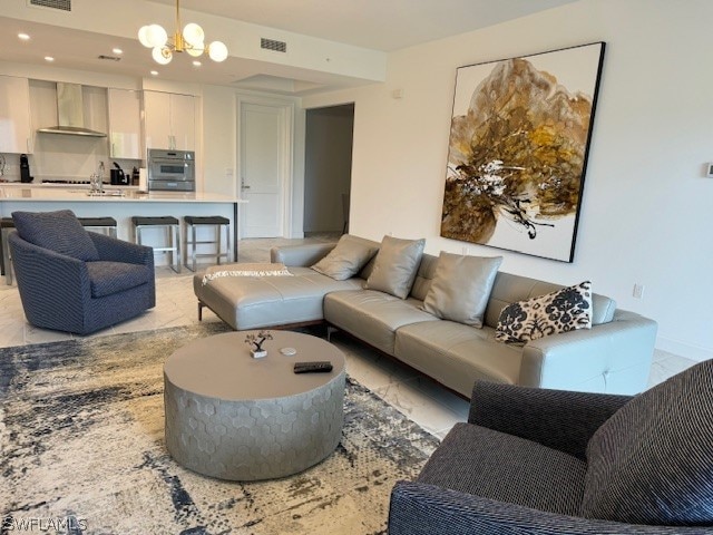 tiled living room featuring sink and a chandelier