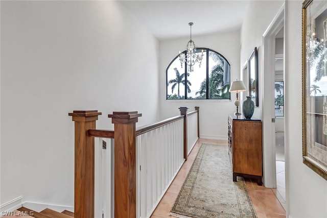 hallway featuring light tile patterned floors and an inviting chandelier