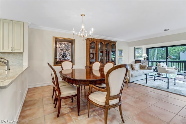 dining area with a notable chandelier, sink, light tile patterned floors, and crown molding