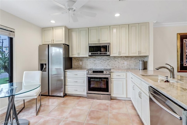 kitchen featuring light stone countertops, sink, ceiling fan, backsplash, and appliances with stainless steel finishes