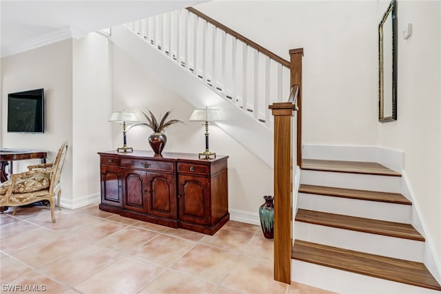 staircase with tile patterned flooring and crown molding