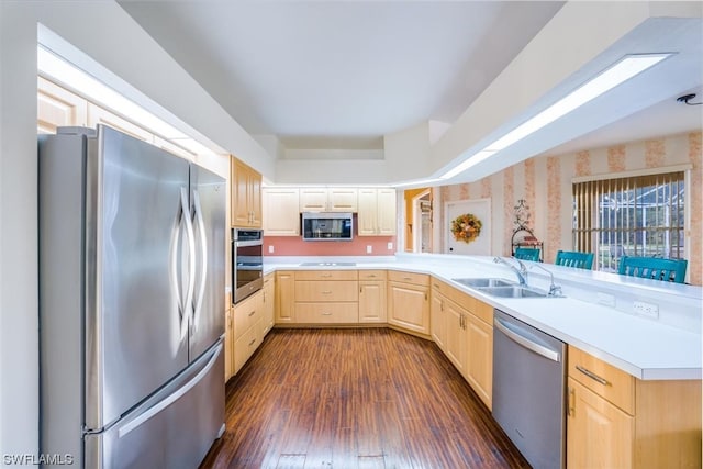 kitchen featuring kitchen peninsula, sink, dark hardwood / wood-style flooring, stainless steel appliances, and light brown cabinets