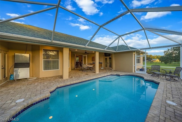 view of swimming pool featuring a patio area, ceiling fan, and a lanai