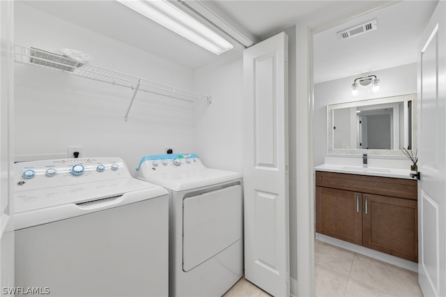 washroom featuring washer and clothes dryer, sink, and light tile patterned floors