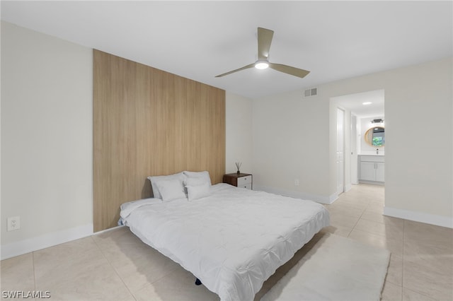 tiled bedroom with ensuite bath and ceiling fan