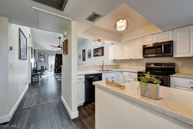 kitchen with light stone counters, appliances with stainless steel finishes, white cabinetry, dark hardwood / wood-style floors, and sink