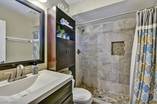 bathroom featuring toilet, walk in shower, and vanity