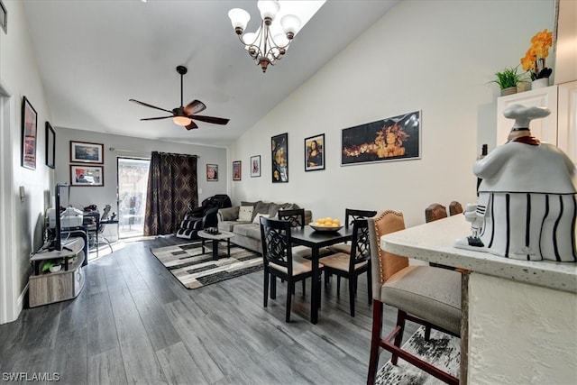 dining room featuring high vaulted ceiling, wood-type flooring, and ceiling fan with notable chandelier