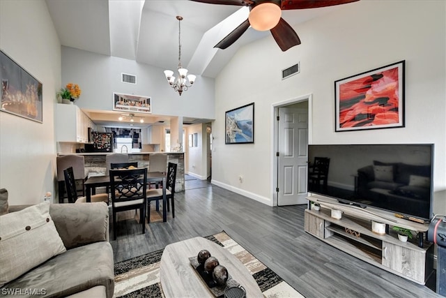 living room featuring high vaulted ceiling, hardwood / wood-style flooring, and ceiling fan with notable chandelier