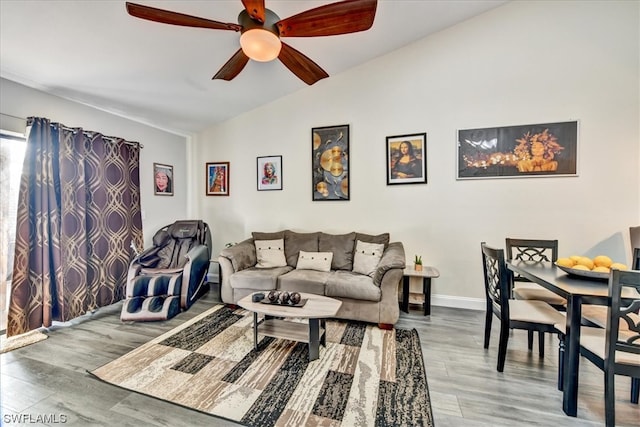 living room with lofted ceiling, hardwood / wood-style floors, and ceiling fan