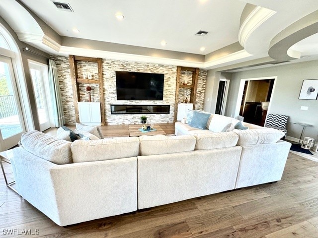 living room with hardwood / wood-style floors and a tray ceiling