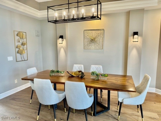 dining room with a chandelier, light hardwood / wood-style flooring, and ornamental molding