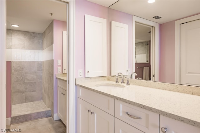 bathroom featuring vanity, tile floors, and a tile shower