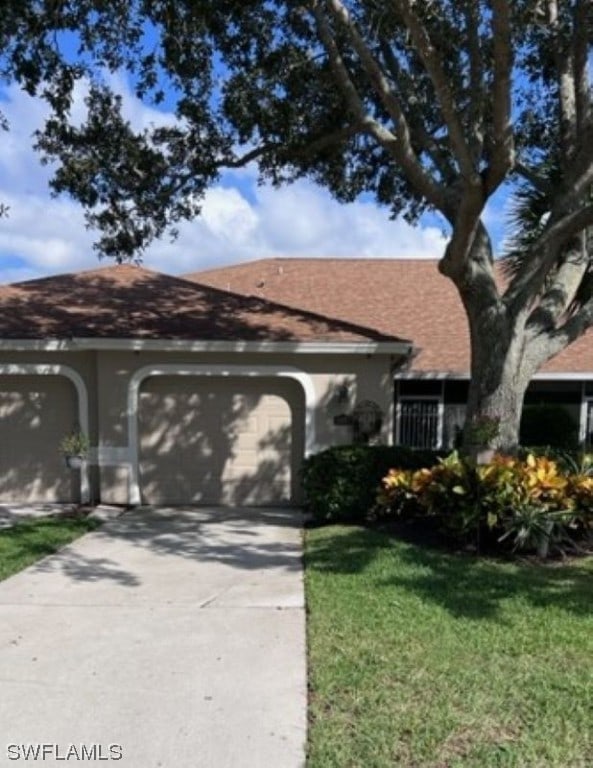 ranch-style home with a front lawn and a garage