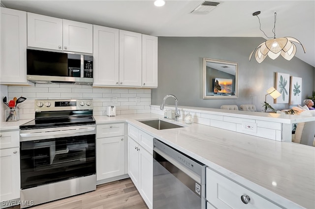 kitchen featuring white cabinets, sink, appliances with stainless steel finishes, and light hardwood / wood-style flooring