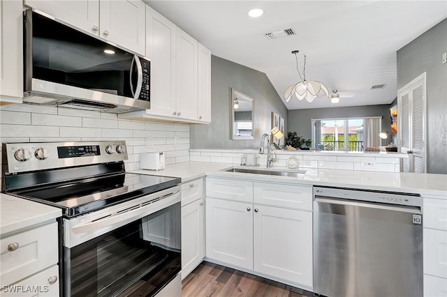 kitchen with white cabinets, stainless steel appliances, kitchen peninsula, and sink