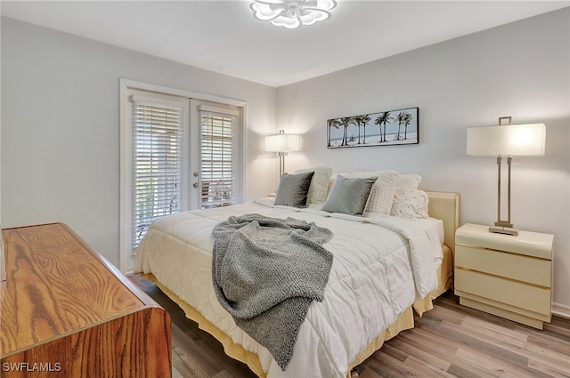 bedroom with access to exterior and hardwood / wood-style floors