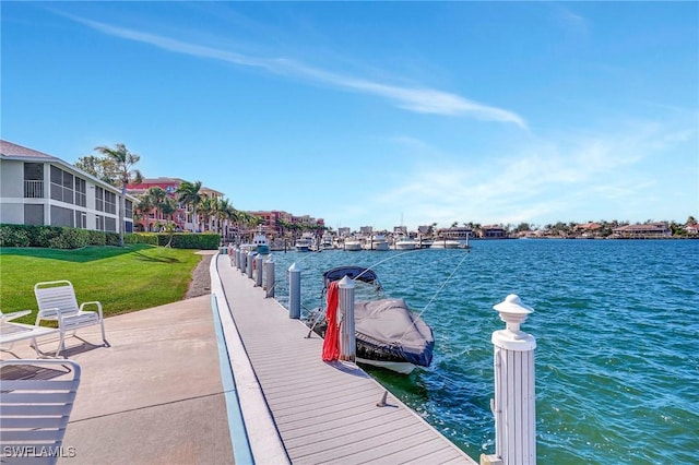 view of dock with a yard and a water view