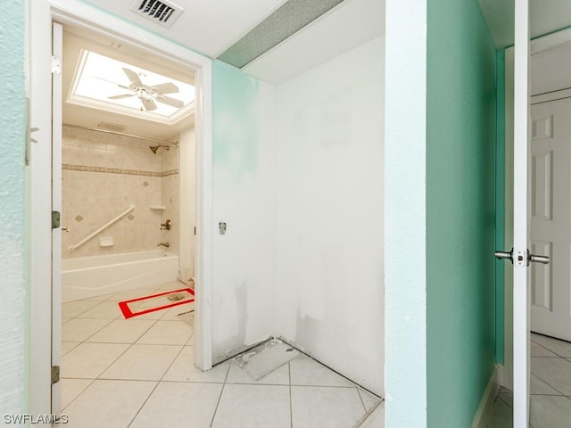 bathroom with tiled shower / bath combo, tile patterned floors, and ceiling fan