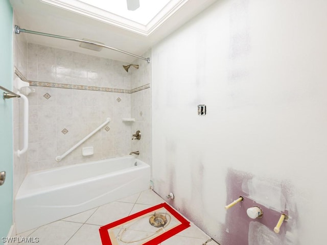 bathroom featuring tiled shower / bath, a skylight, and tile patterned flooring