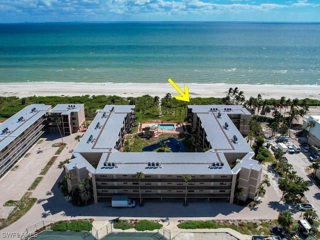 bird's eye view with a water view and a beach view