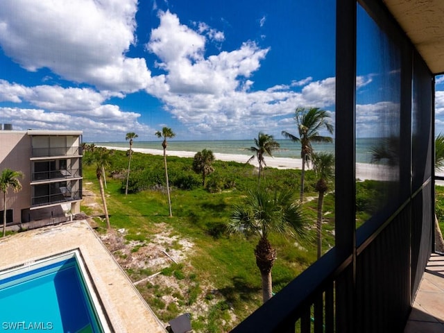 balcony with a water view and a view of the beach