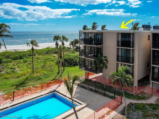 view of pool featuring a water view and a view of the beach