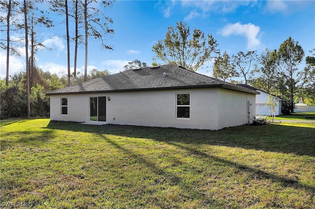 back of property featuring a lawn