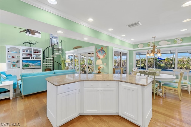 kitchen with a center island with sink, light hardwood / wood-style floors, white cabinetry, and light stone counters