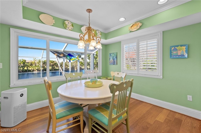 dining area featuring an inviting chandelier, ornamental molding, and light hardwood / wood-style flooring