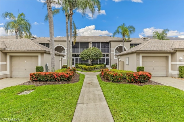 townhome / multi-family property with a front yard and a garage