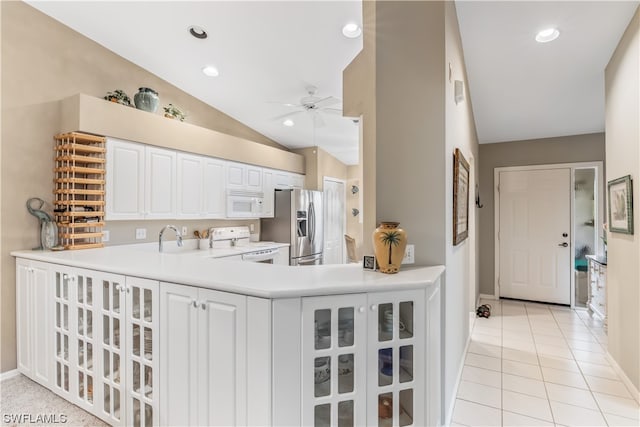 kitchen with kitchen peninsula, white appliances, ceiling fan, vaulted ceiling, and white cabinetry