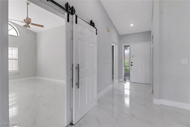 corridor featuring a barn door and light tile floors